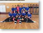 Mgr. Minárová a družstvo dievčat s florbalovym vybavením v telocvični školy