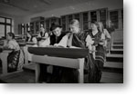 Dnes alebo minulosť? - čiernobiela fotografia súčasných žiakov gymnázia v krojoch v laviciach fyzikálnej posluchárne