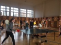 �ia�ka po�as hrania stoln�ho tenisu a �al�� �iaci v telocvi�ni �koly